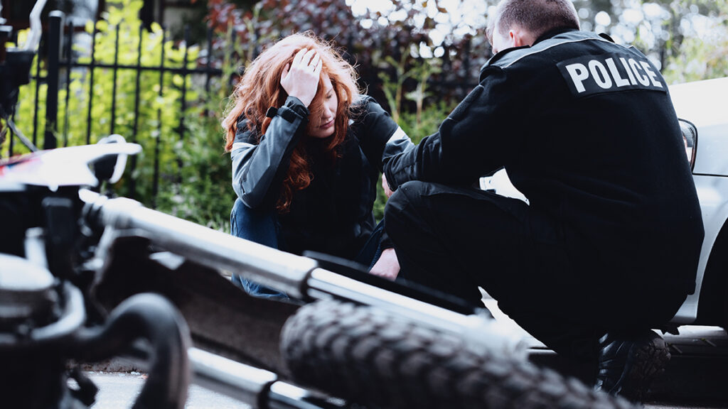 Traumatic-Brain-Injury-Team-Green-Law 3 | Team Green Law Police officer helps someone involved in a motorcycle accident and suffering from a traumatic brain injury accident.