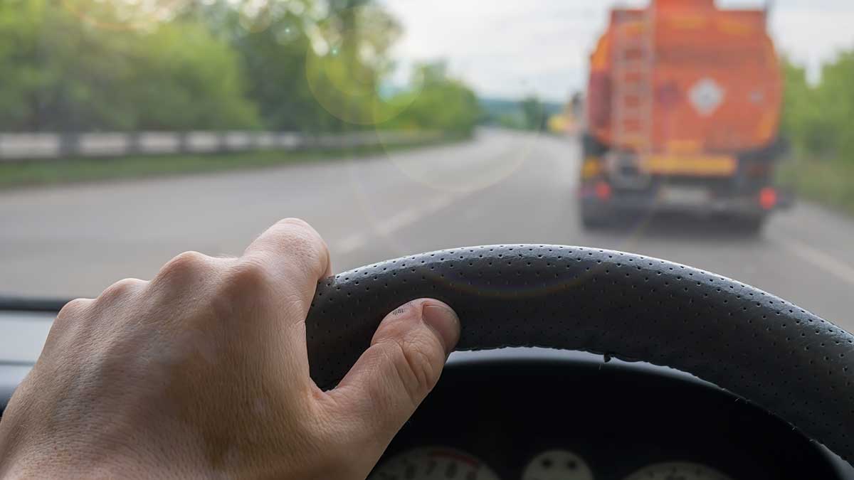 Driver hold steering wheel while driving down highway