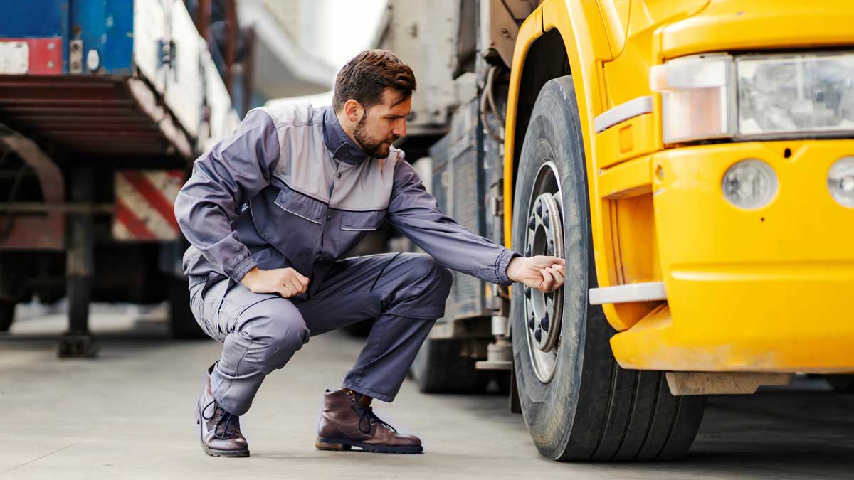Truck driver checks tire pressure