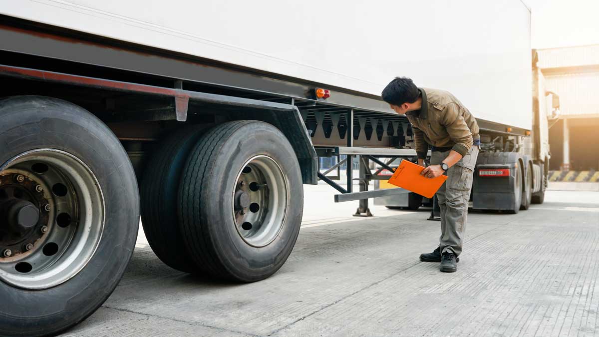 Semi truck driver inspects truck before road trip